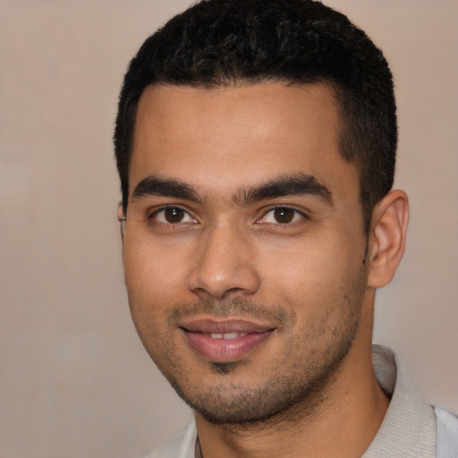 Joyful latino young-adult male with short  black hair and brown eyes