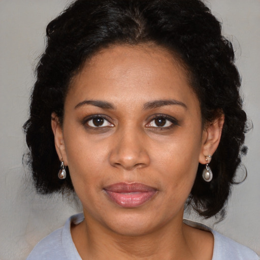 Joyful latino adult female with medium  brown hair and brown eyes