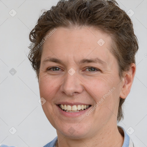 Joyful white adult female with short  brown hair and grey eyes