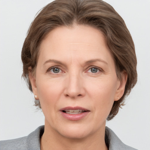 Joyful white adult female with medium  brown hair and grey eyes