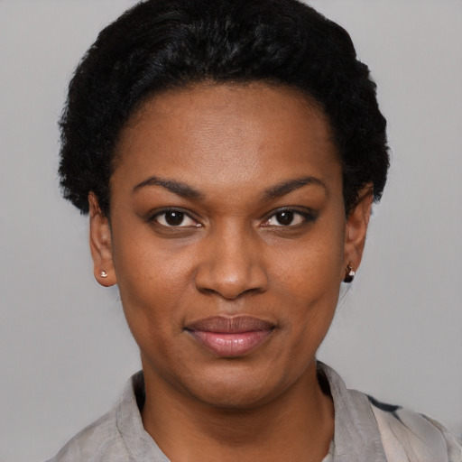 Joyful black young-adult female with short  black hair and brown eyes