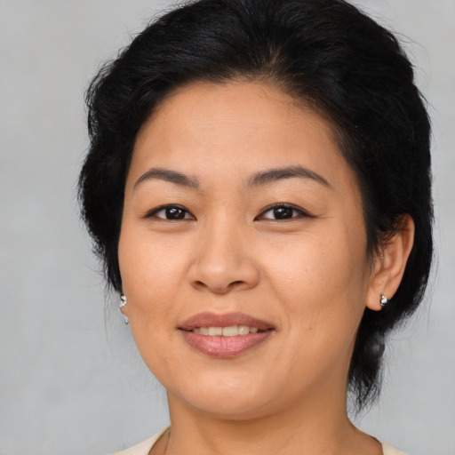 Joyful asian adult female with medium  brown hair and brown eyes