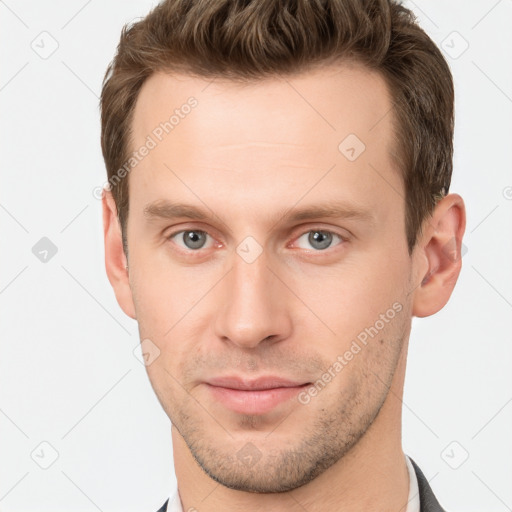 Joyful white young-adult male with short  brown hair and grey eyes