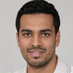 Joyful latino young-adult male with short  black hair and brown eyes