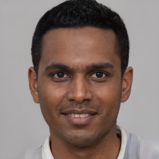 Joyful black young-adult male with short  black hair and brown eyes