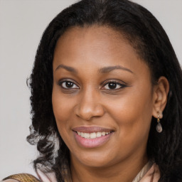 Joyful black young-adult female with long  brown hair and brown eyes