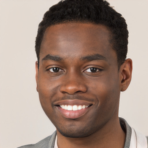 Joyful black young-adult male with short  brown hair and brown eyes