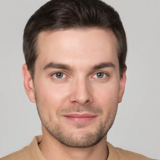 Joyful white young-adult male with short  brown hair and grey eyes