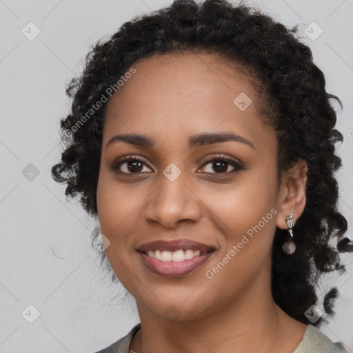 Joyful black young-adult female with long  black hair and brown eyes