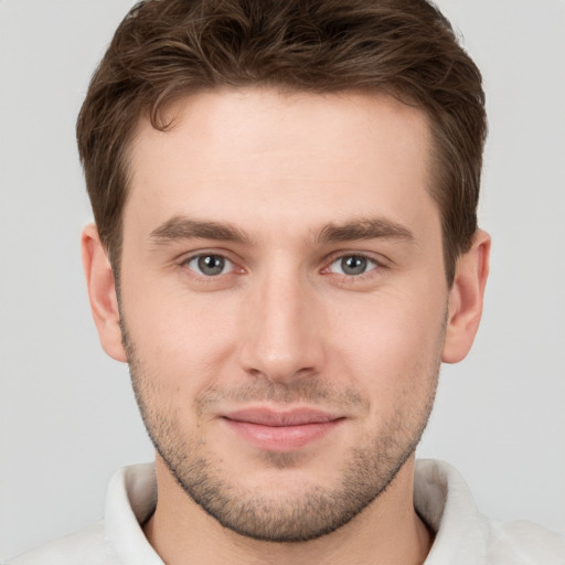 Joyful white young-adult male with short  brown hair and grey eyes