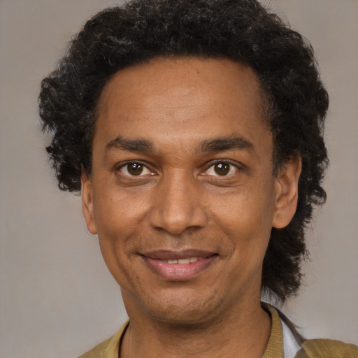 Joyful black adult male with short  brown hair and brown eyes