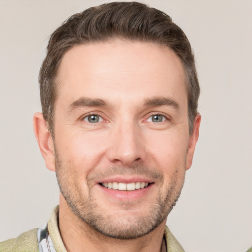 Joyful white young-adult male with short  brown hair and grey eyes