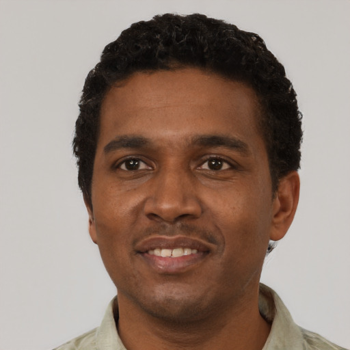 Joyful black young-adult male with short  black hair and brown eyes