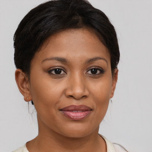 Joyful black young-adult female with short  brown hair and brown eyes