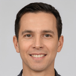 Joyful white young-adult male with short  brown hair and brown eyes