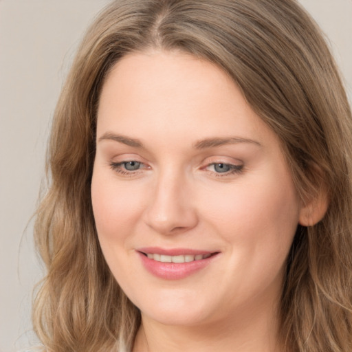 Joyful white young-adult female with long  brown hair and grey eyes