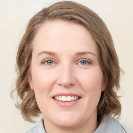 Joyful white young-adult female with medium  brown hair and blue eyes