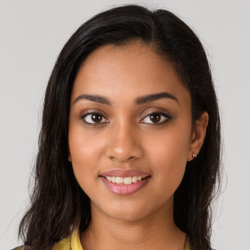 Joyful latino young-adult female with long  brown hair and brown eyes