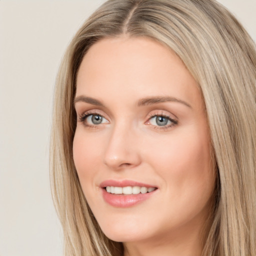 Joyful white young-adult female with long  brown hair and blue eyes