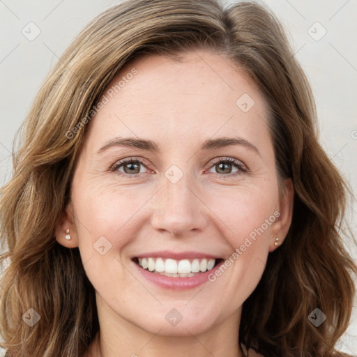 Joyful white young-adult female with long  brown hair and green eyes