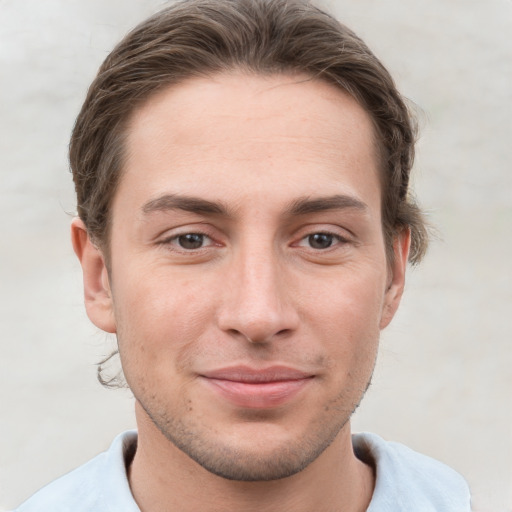 Joyful white young-adult male with short  brown hair and grey eyes