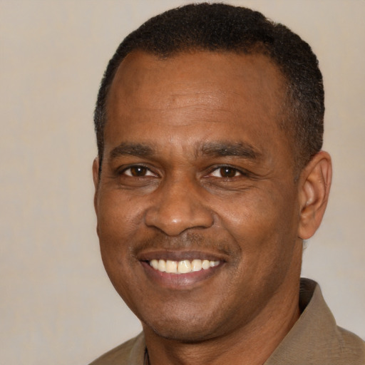 Joyful black young-adult male with short  black hair and brown eyes