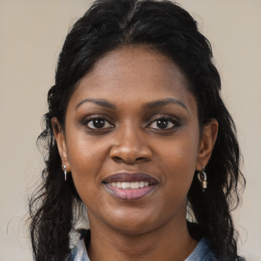 Joyful black young-adult female with long  black hair and brown eyes