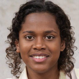 Joyful black young-adult female with medium  brown hair and brown eyes