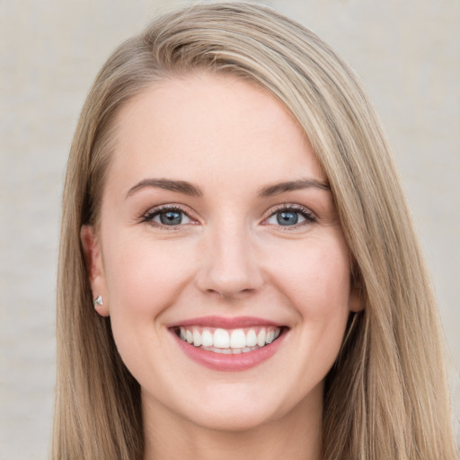 Joyful white young-adult female with long  brown hair and blue eyes