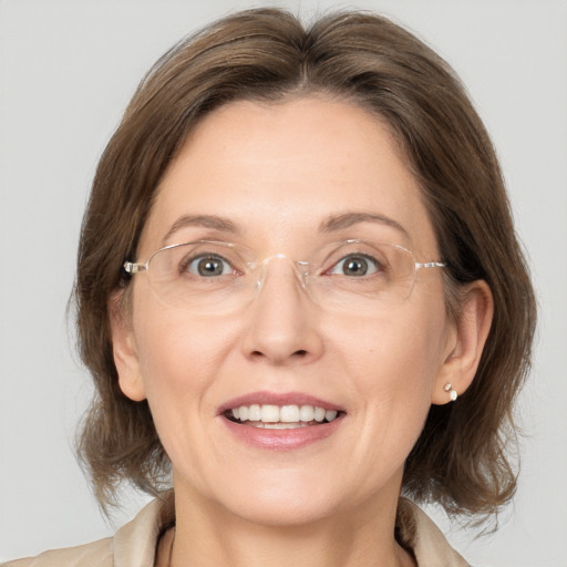 Joyful white adult female with medium  brown hair and grey eyes