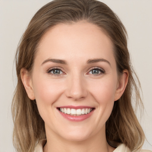 Joyful white young-adult female with medium  brown hair and grey eyes