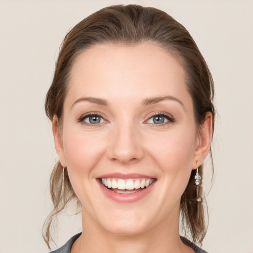 Joyful white young-adult female with medium  brown hair and grey eyes