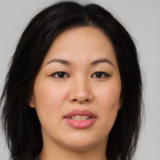 Joyful asian young-adult female with long  brown hair and brown eyes