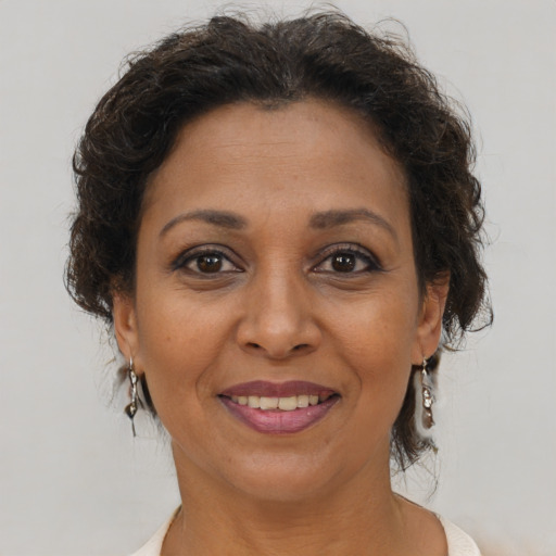 Joyful black adult female with medium  brown hair and brown eyes
