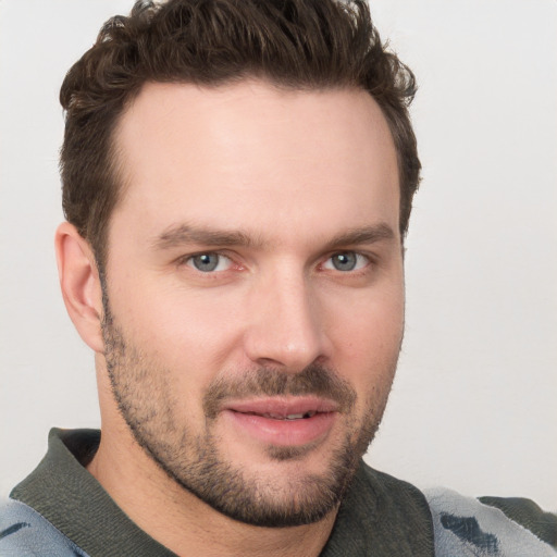 Joyful white young-adult male with short  brown hair and blue eyes