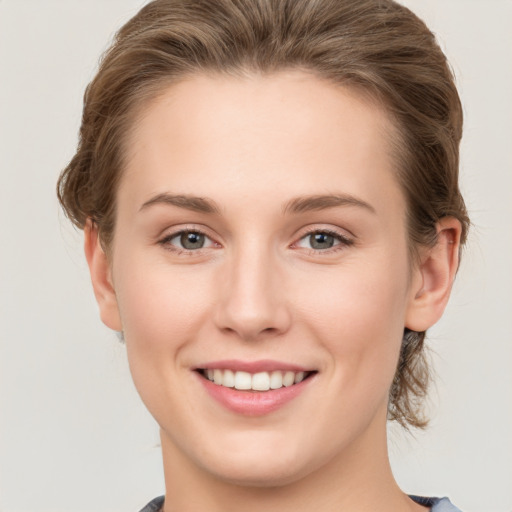 Joyful white young-adult female with short  brown hair and grey eyes