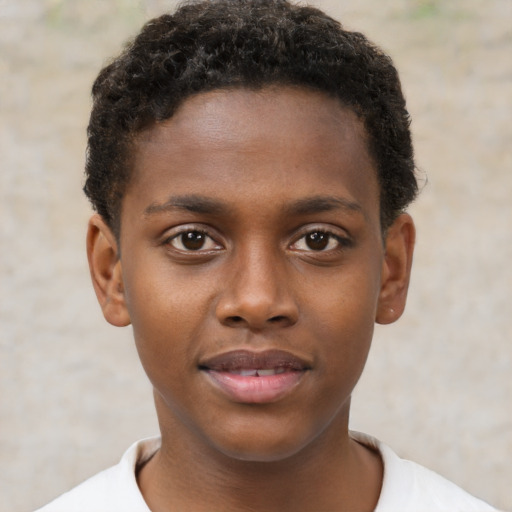 Joyful black child male with short  brown hair and brown eyes