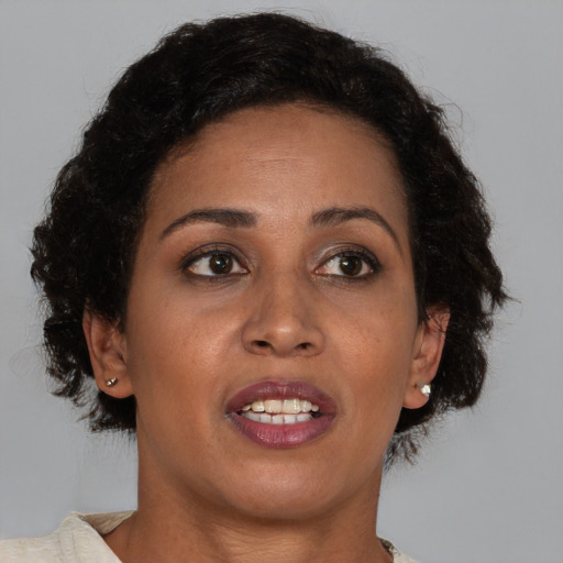 Joyful black adult female with medium  brown hair and brown eyes