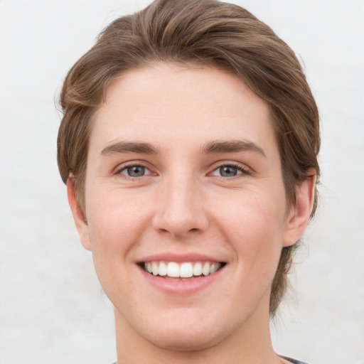 Joyful white young-adult female with short  brown hair and grey eyes