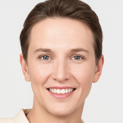 Joyful white young-adult female with short  brown hair and grey eyes