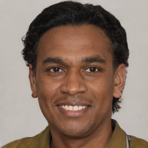 Joyful latino adult male with short  black hair and brown eyes