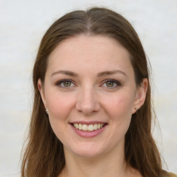 Joyful white young-adult female with long  brown hair and green eyes