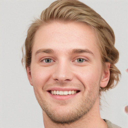 Joyful white young-adult male with short  brown hair and blue eyes