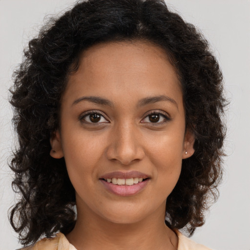 Joyful black young-adult female with long  brown hair and brown eyes