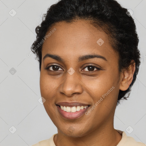 Joyful black young-adult female with short  brown hair and brown eyes