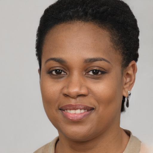 Joyful black young-adult female with short  brown hair and brown eyes
