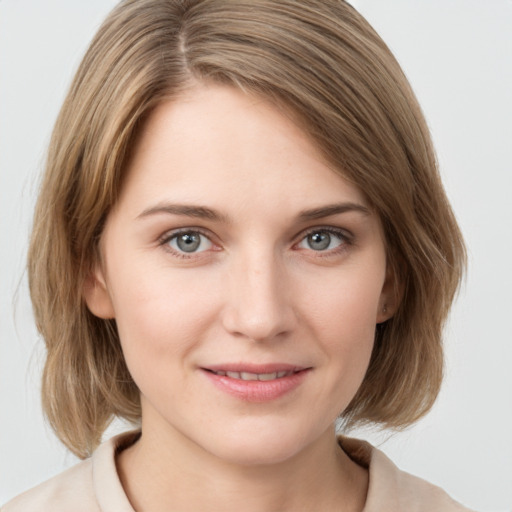 Joyful white young-adult female with medium  brown hair and grey eyes