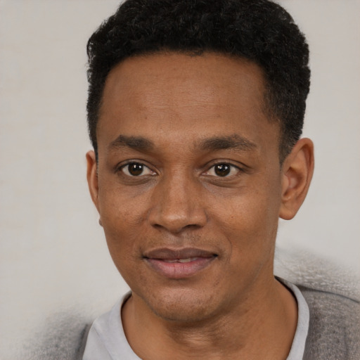 Joyful black young-adult male with short  black hair and brown eyes