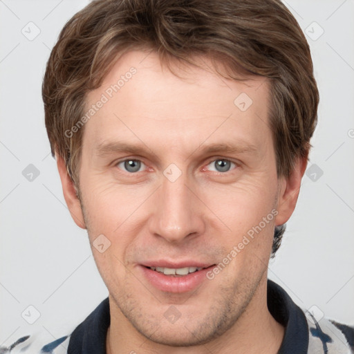 Joyful white young-adult male with short  brown hair and grey eyes