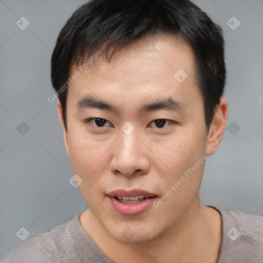 Joyful asian young-adult male with short  brown hair and brown eyes